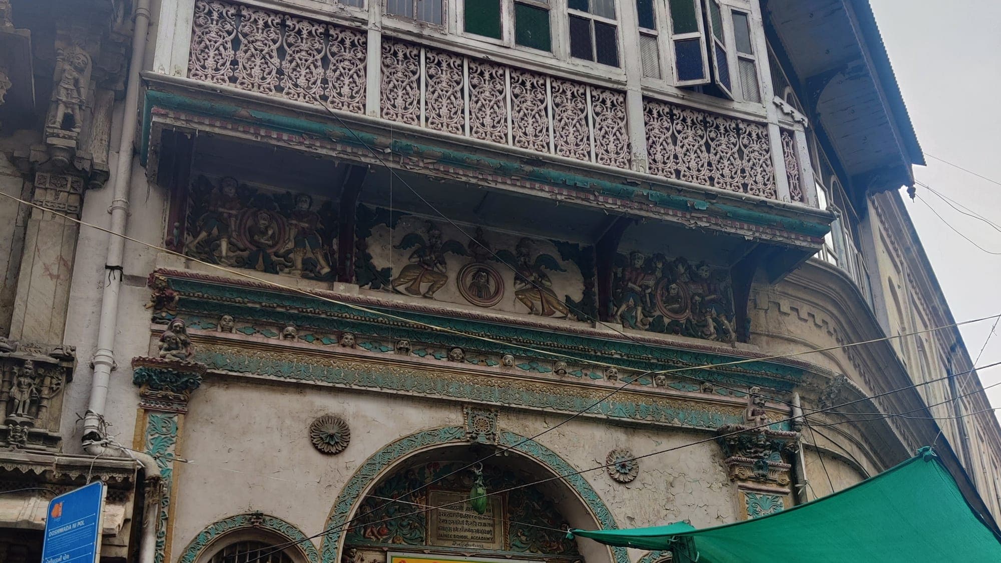 Shopfronts under awnings in the old city of Ahmedabad, signage in Gujarati