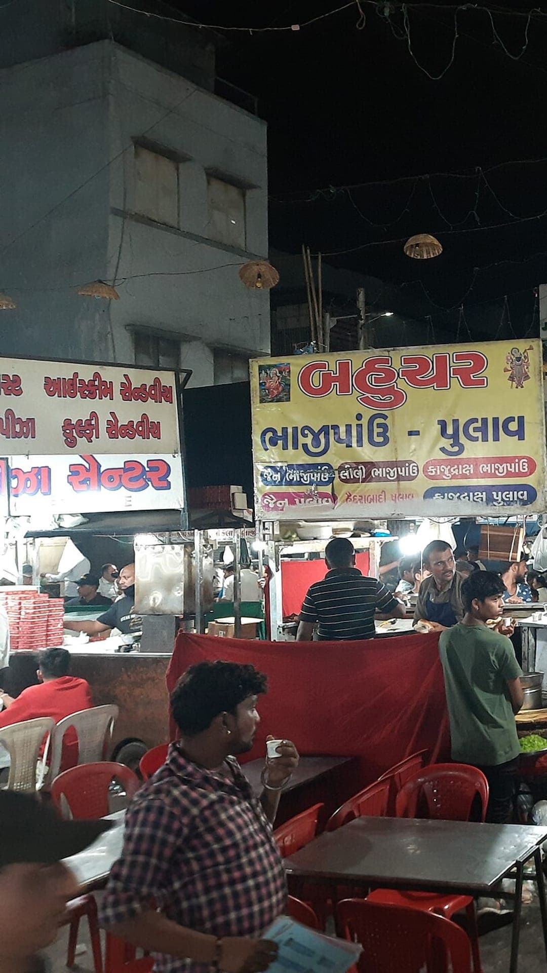 Crowds at Manek Chowk night food market in Ahmedabad, stalls lit under signage